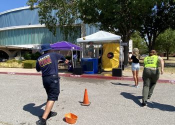 Corporal Stiven Jimenez, Lawton Fire Department, throws ball at the dunk tank where Dr. Krista Ratliff, president and CEO of Lawton-Fort Sill Chamber of Commerce, awaits the splash. Photos by Curtis Awbrey