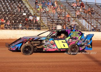 WAITING: Jim Bland sits in the seat of the No. 16 car as the fans rise in the background in anticipation of the national anthem before the start of the Rob Bland Memorial Race. Photo by Mike Howard Photography